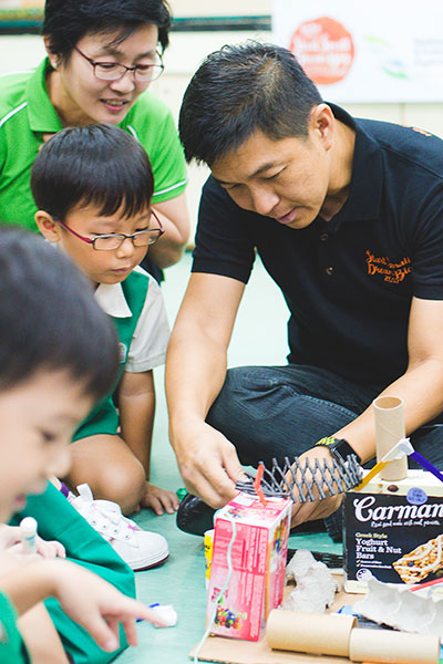 Minister for Social and Family Development, Mr Tan Chuan-Jin, working with the children on one of the recycle projects. 
