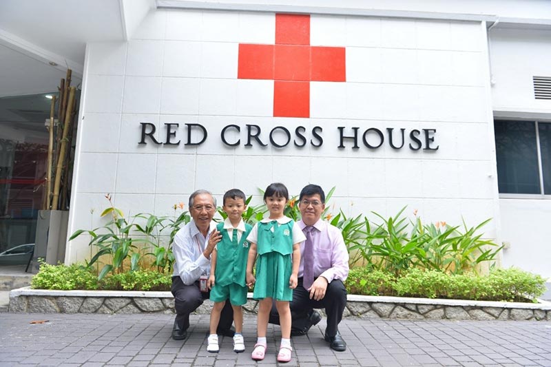 Mr Lim Theam Poh, Deputy Secretary General (Administration), of the Singapore Red Cross Society, together with Kinderland students.